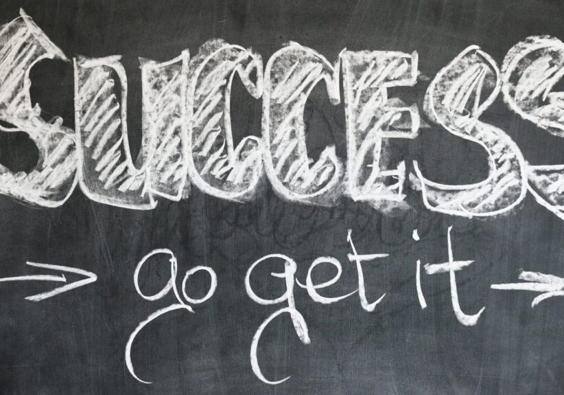 A chalkboard with the word success written in chalk.